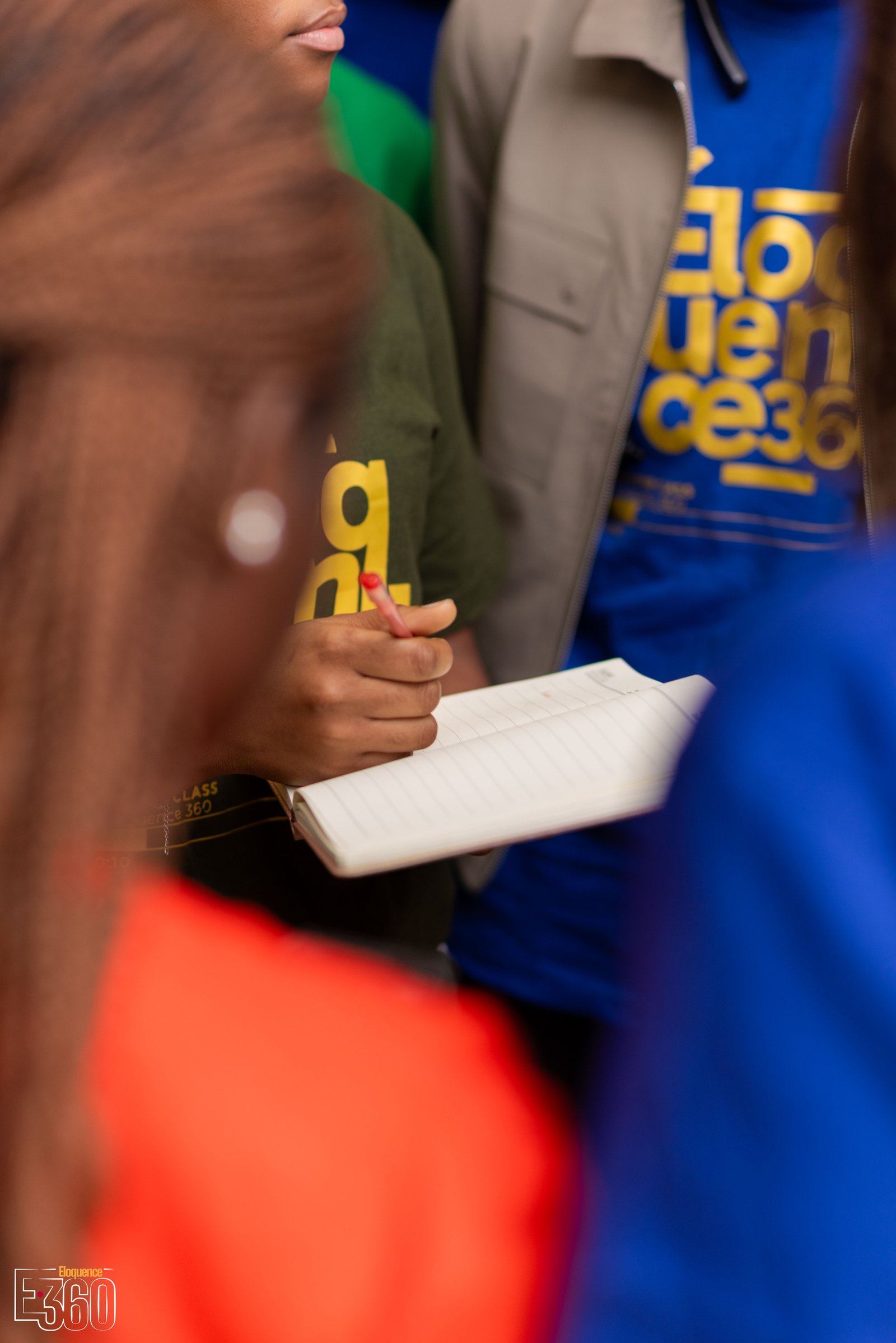 Une participante prend des notes dans un carnet pendant un échange.