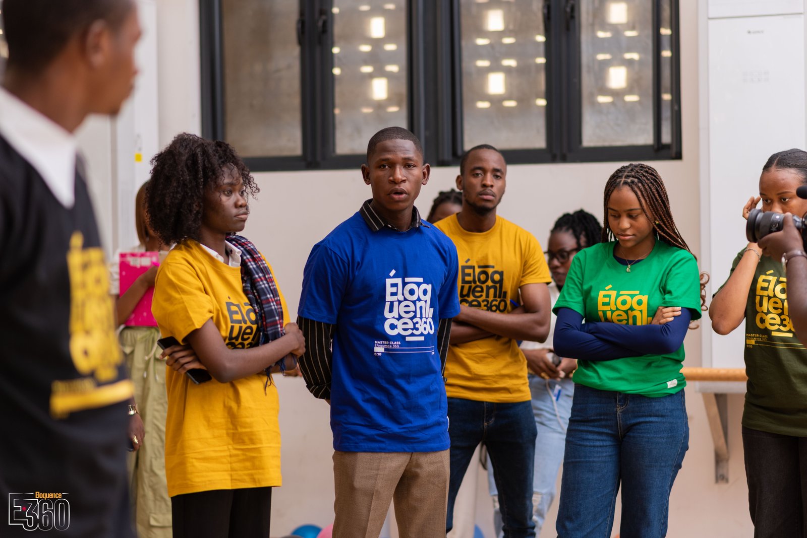 Un participant en tee-shirt bleu s’exprime devant les autres participants.