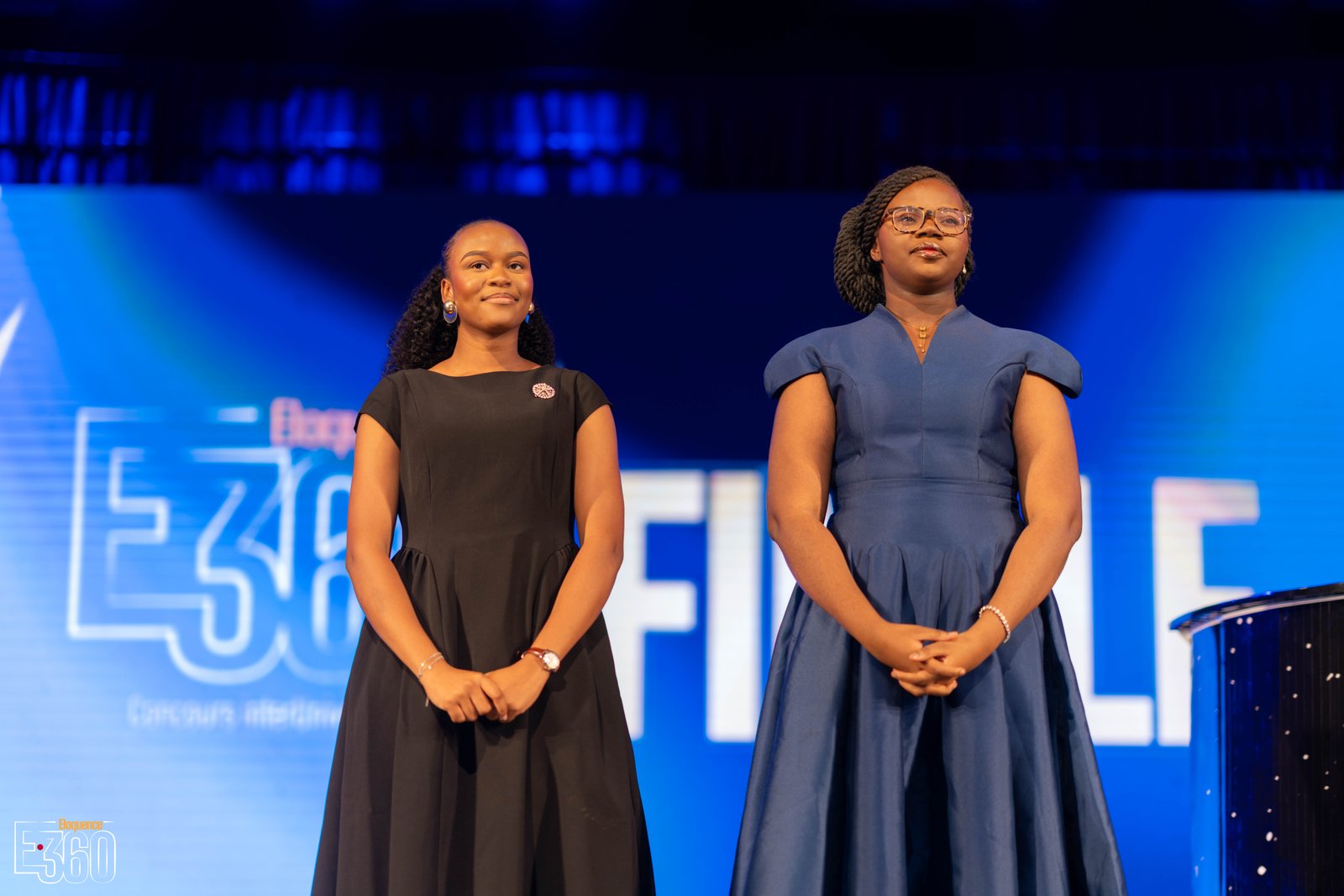 Deux finalistes se tiennent sur la scène de la grande finale Éloquence 360.