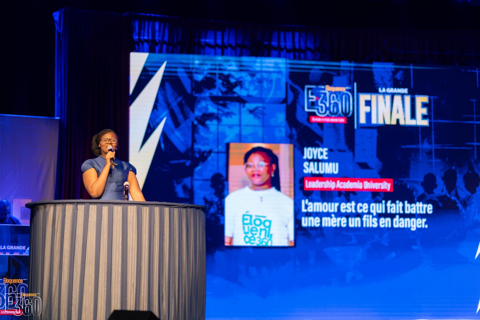 Une finaliste prend la parole au pupitre sur la scène de la grande finale Éloquence 360.