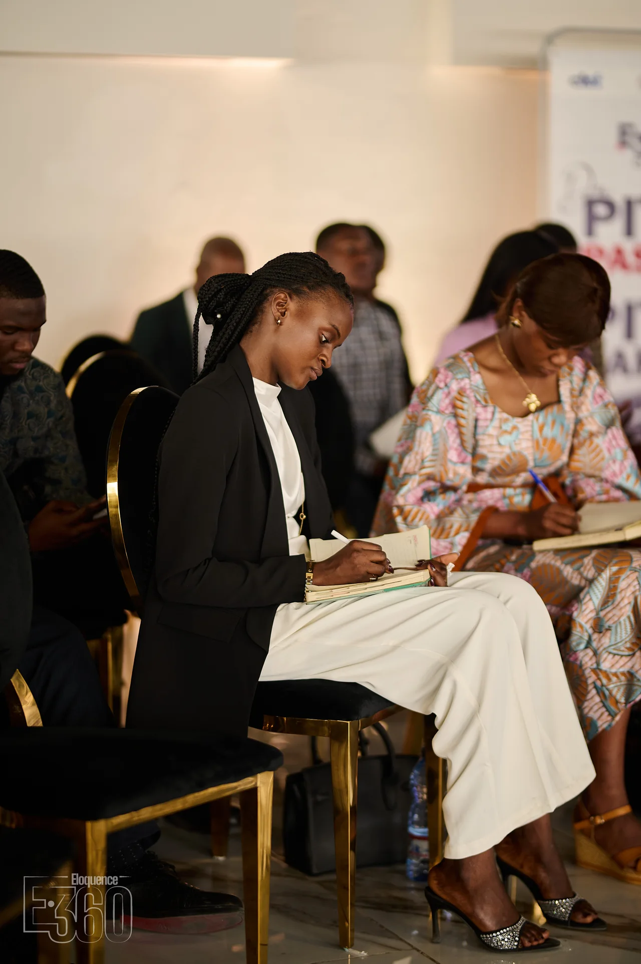 Deux participantes prennent des notes dans leurs carnets.