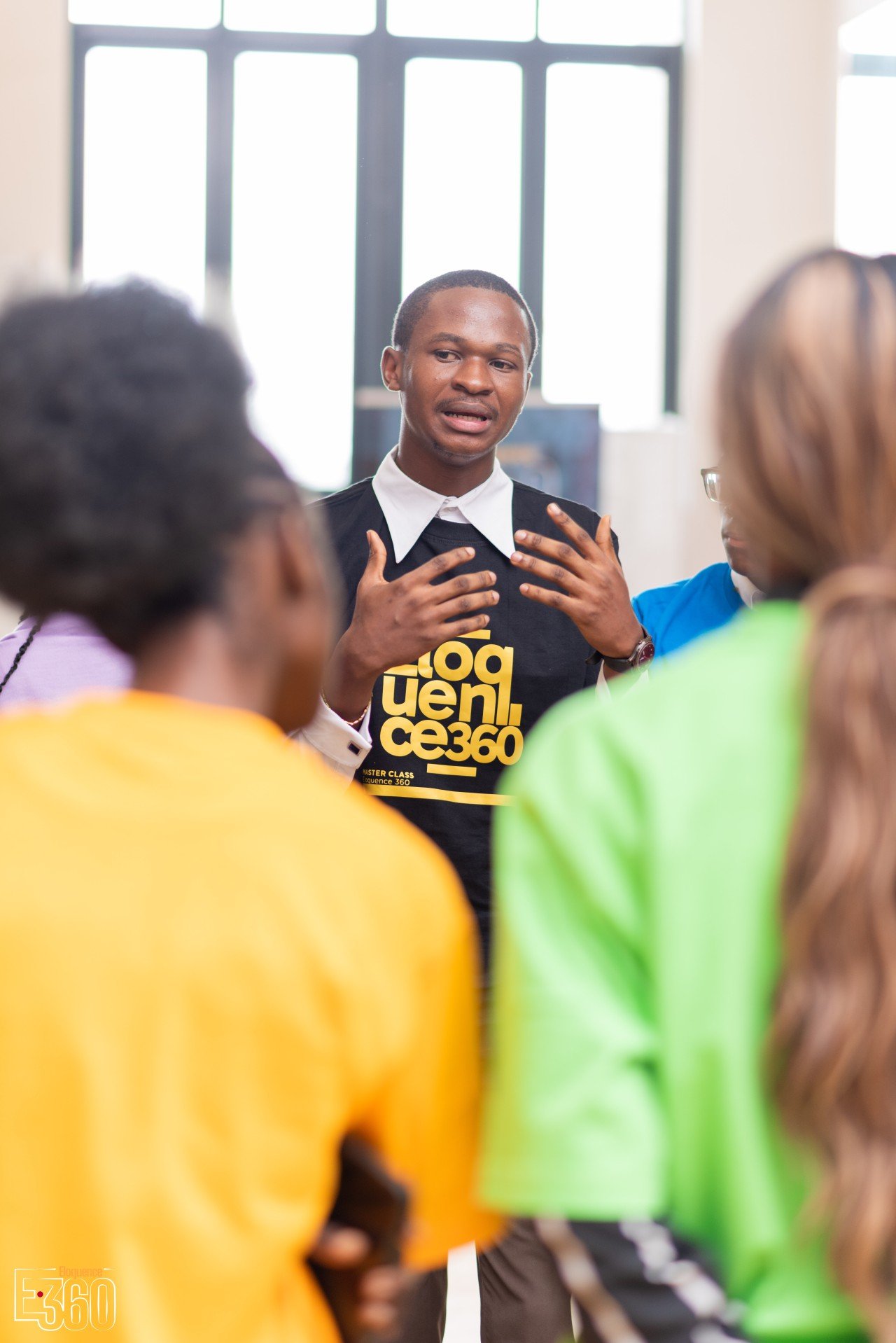 Un participant debout parle en accompagnant ses mots d’un geste des mains.