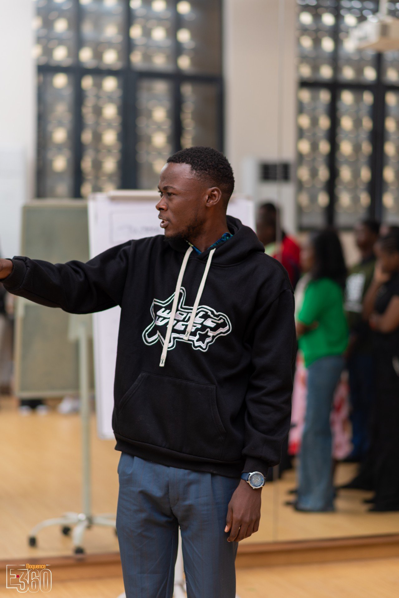 Un participant en sweat noir s’exprime debout devant le groupe.