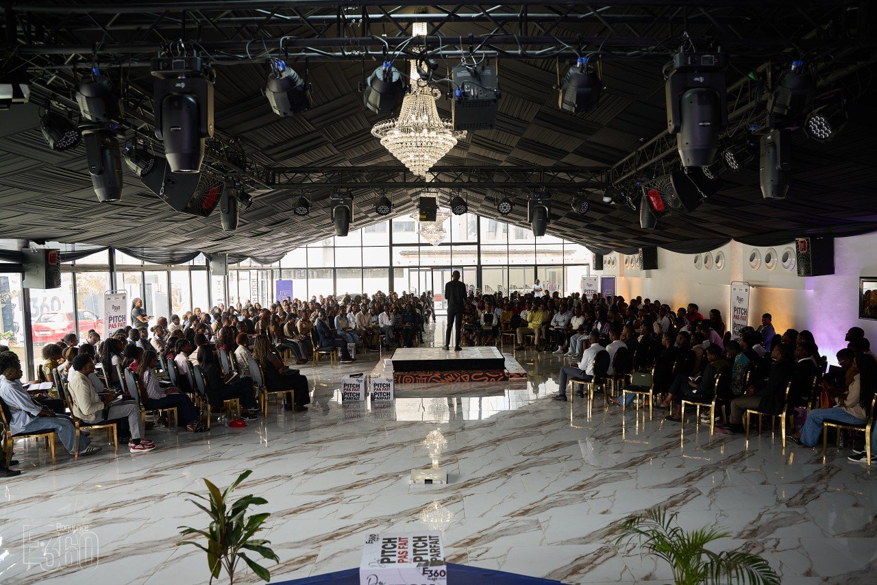 Une assemblée réunie autour d’une estrade dans une grande salle.