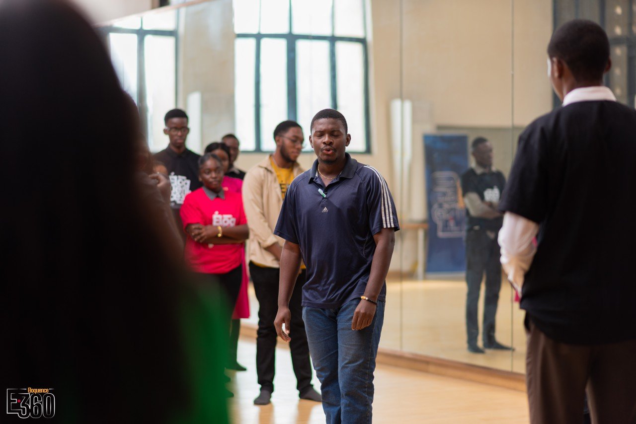 Un participant s’exprime face à une autre personne pendant que le groupe observe.
