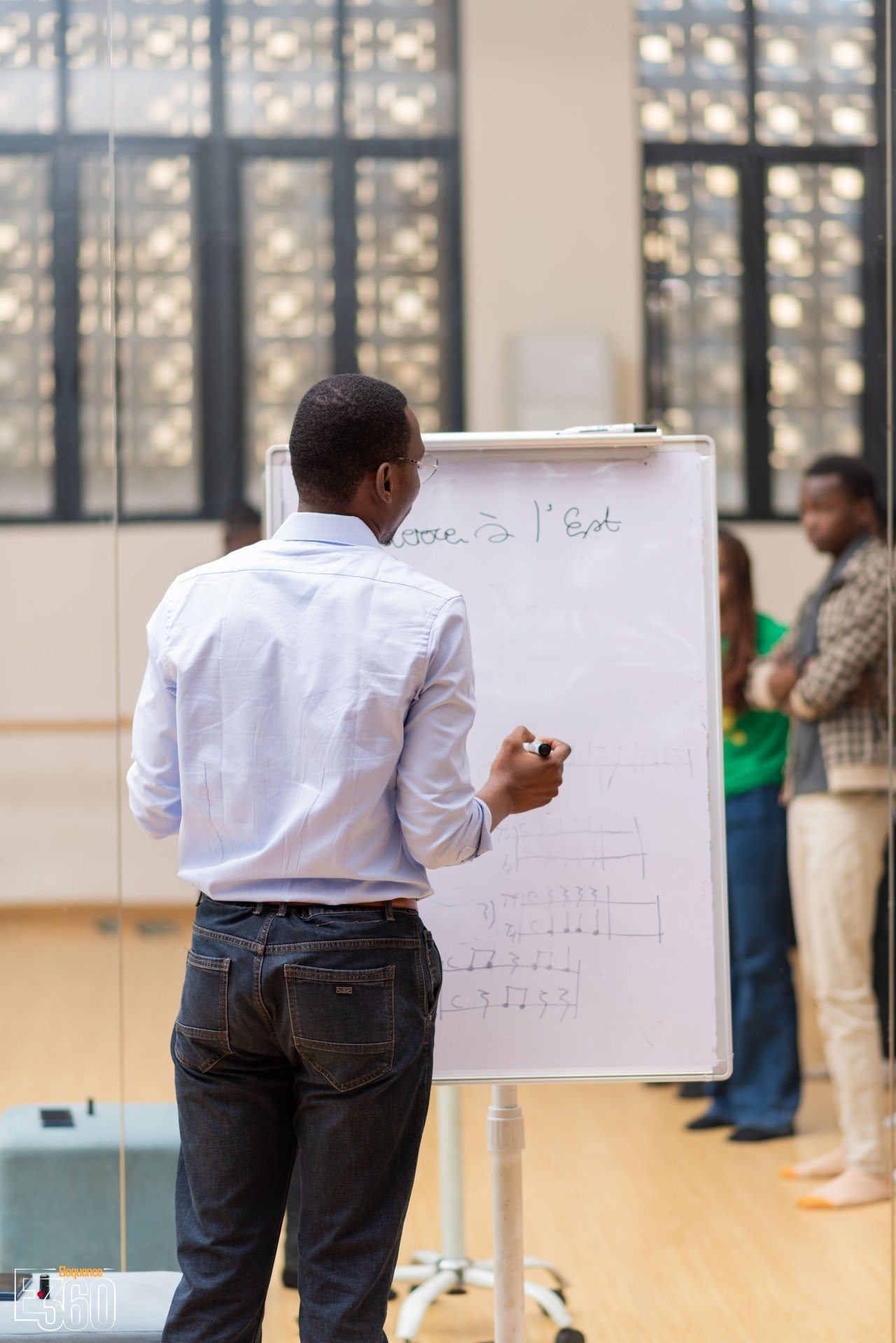 Un intervenant écrit sur un tableau à feuilles dans une salle de travail.