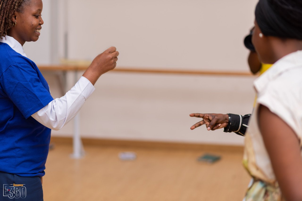 Deux participantes échangent, les mains en mouvement, pendant un exercice collectif.