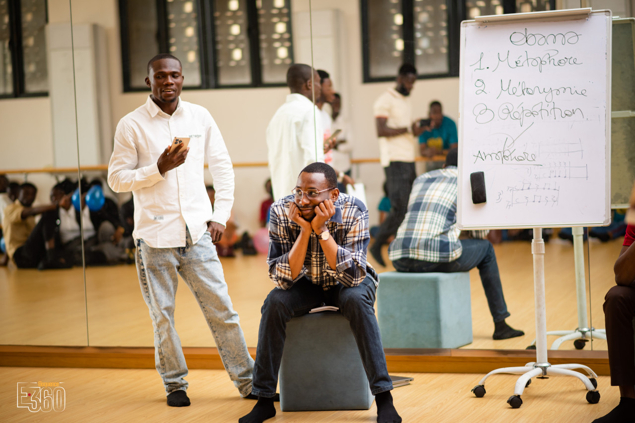 Des participants prennent part à un exercice avec un intervenant, près d’un tableau de travail.